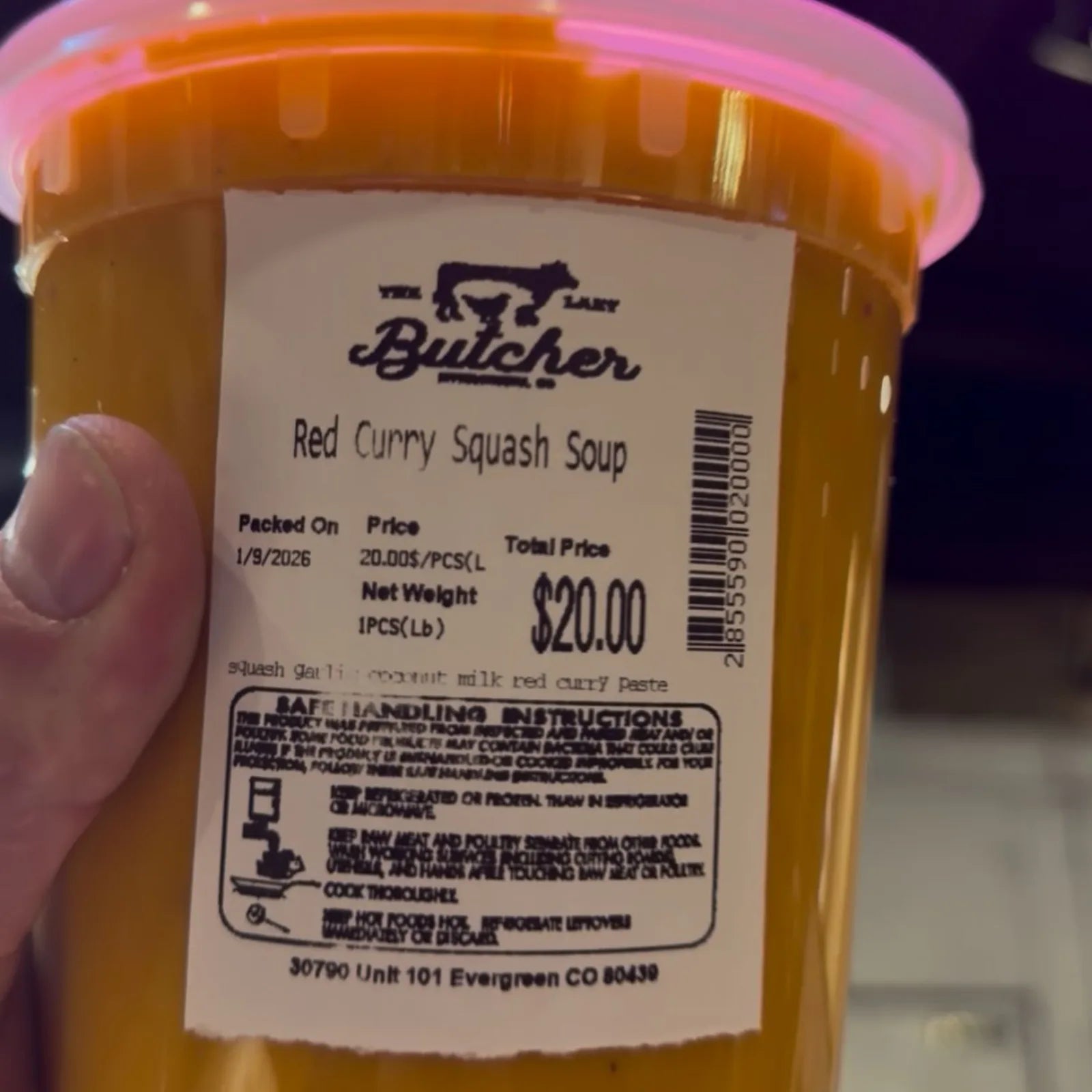 A container of house-made red curry squash soup