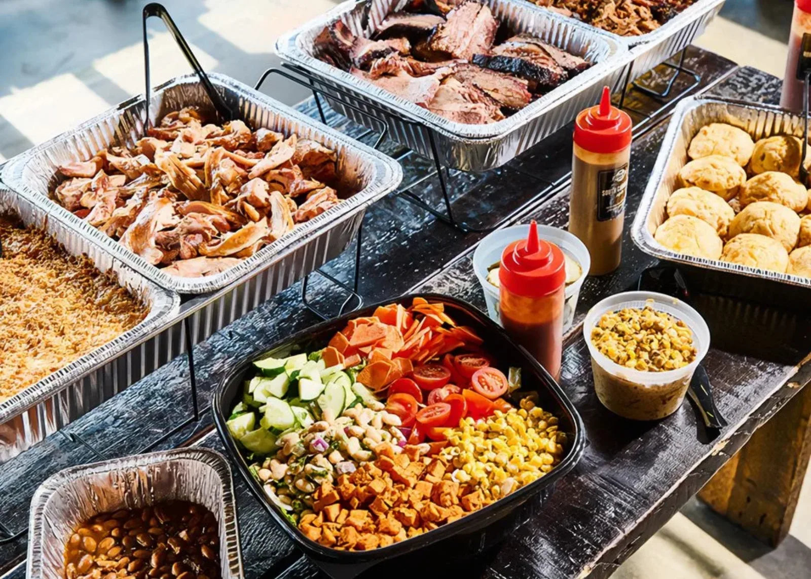 A backyard BBQ catering spread of smoked meats and sides